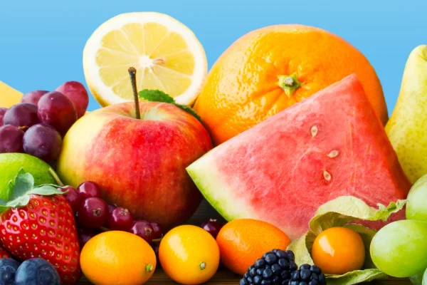 A variety of fruits that help develop Antioxidants including Banana, Grapes, Limes, Lemons, Oranges, Pears, Watermelon, Strawberries, Blueberries, Cranberries and Tomatoes on a blue background.